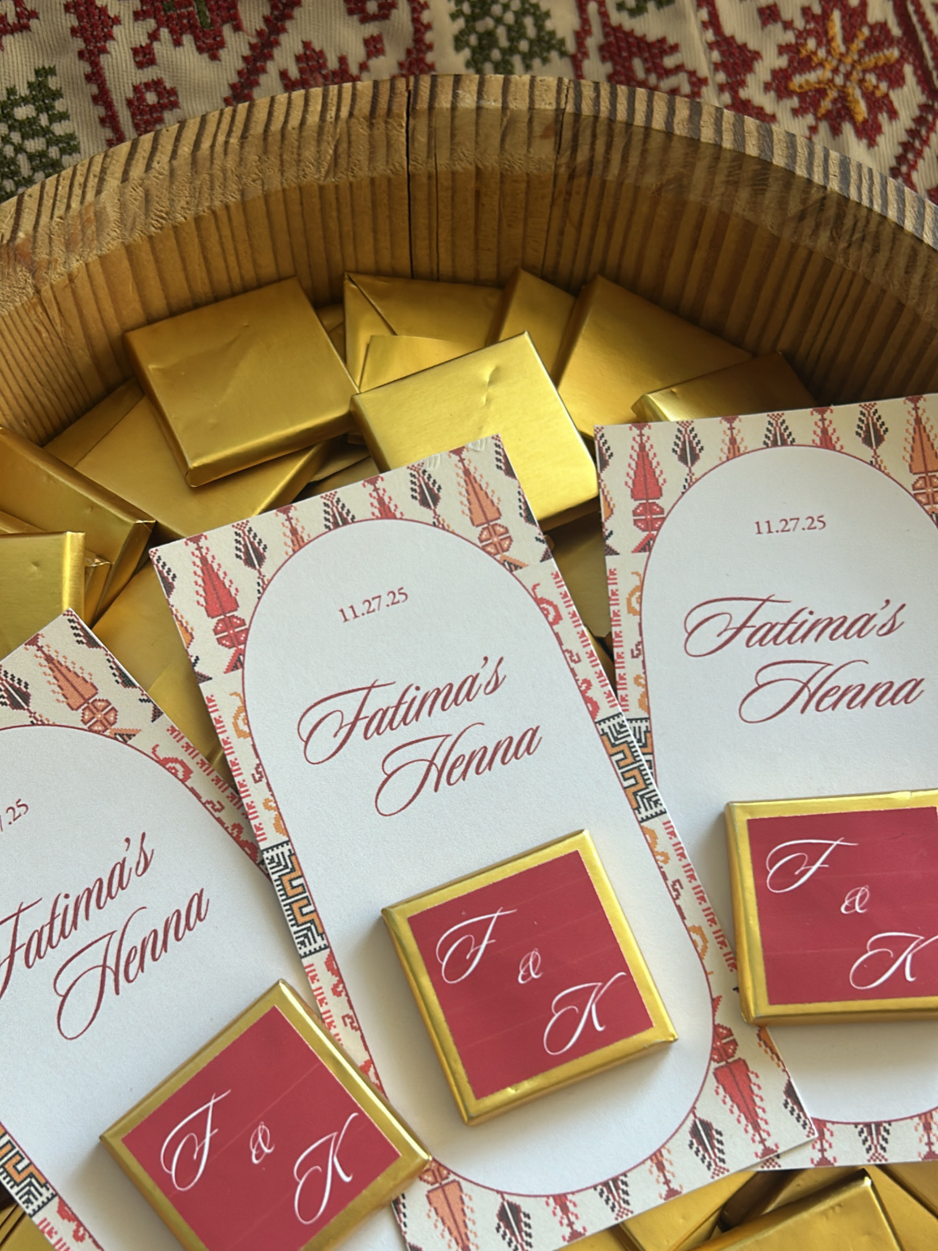 Gold and red boxes with 'Fatima's Henna' on a patterned tatreez background