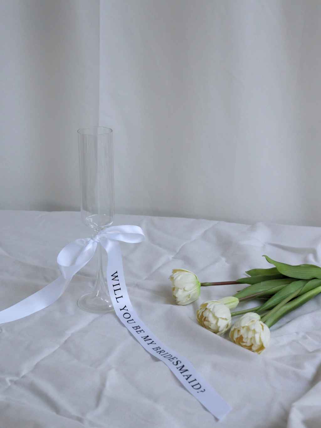Clear glass with a white ribbon and tulips on a white surface, bridesmaid proposal ribbon white long 