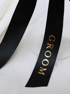 Black ribbon with 'GROOM' text on a white background. groom gold text black personalized ribbon for wedding