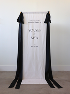 linen wedding welcome sign with black ribbon and gold stand