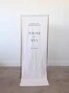 linen welcome sign with gold stand angled straight