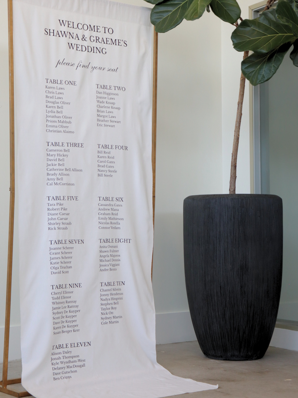 Wedding seating chart banner with plant in the background, wedding linen seating chart gold stand with plant 